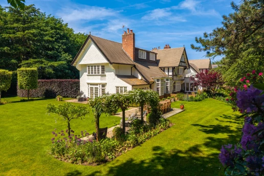 Garden elevation framed by mature trees and lawn at Fieldhead, Prestbury