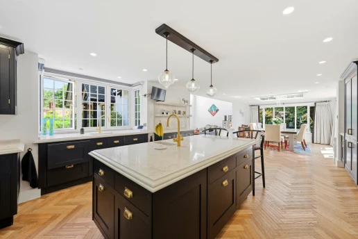 Dark-painted kitchen cabinetry and herringbone floor at Fieldhead, Prestbury