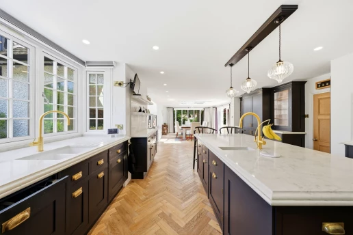 Marble island and brass-accented kitchen at Fieldhead, Prestbury