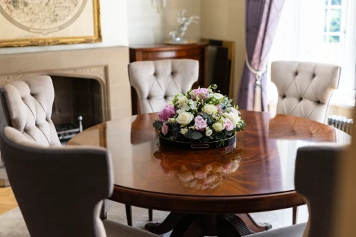 Styled dining table and stone fireplace at Fieldhead, Prestbury